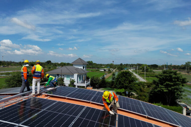 engineer man inspects construction of solar cell panel or photovoltaic cell at roof top. Industrial Renewable energy of green power. factory at urban area. worker working on tower roof.