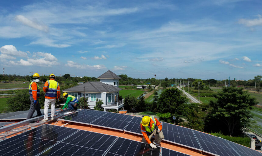 engineer man inspects construction of solar cell panel or photovoltaic cell at roof top. Industrial Renewable energy of green power. factory at urban area. worker working on tower roof.